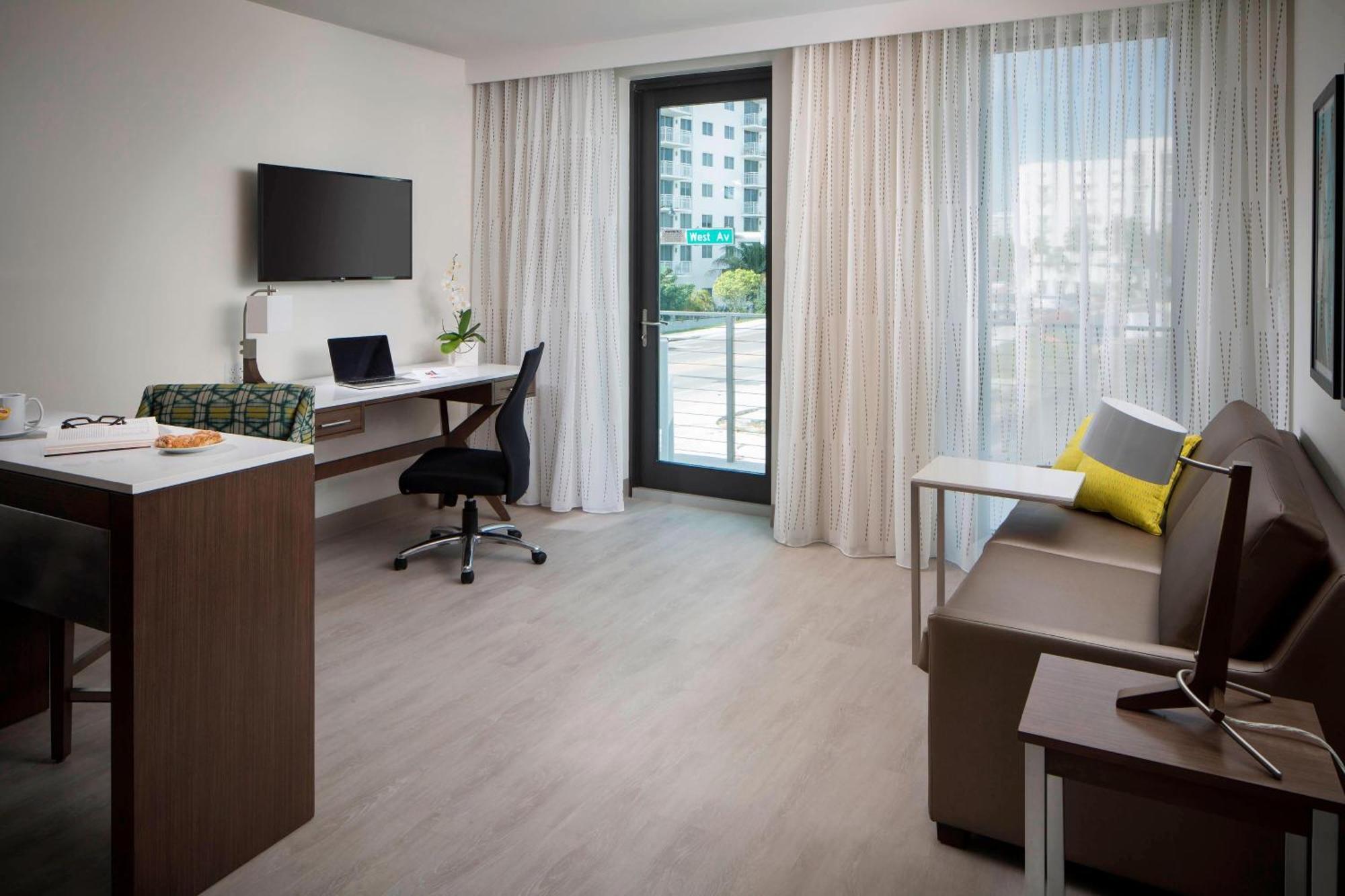 Suite de un dormitorio con cama extragrande, sofá cama y patio